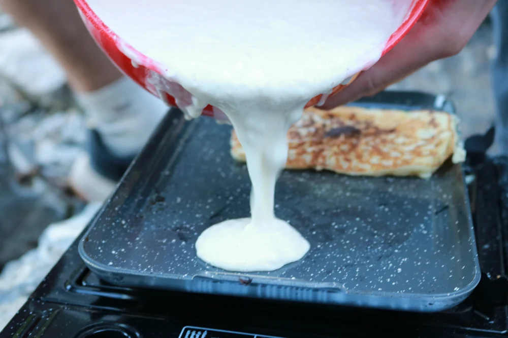 Pouring pancake batter onto the trail griddle